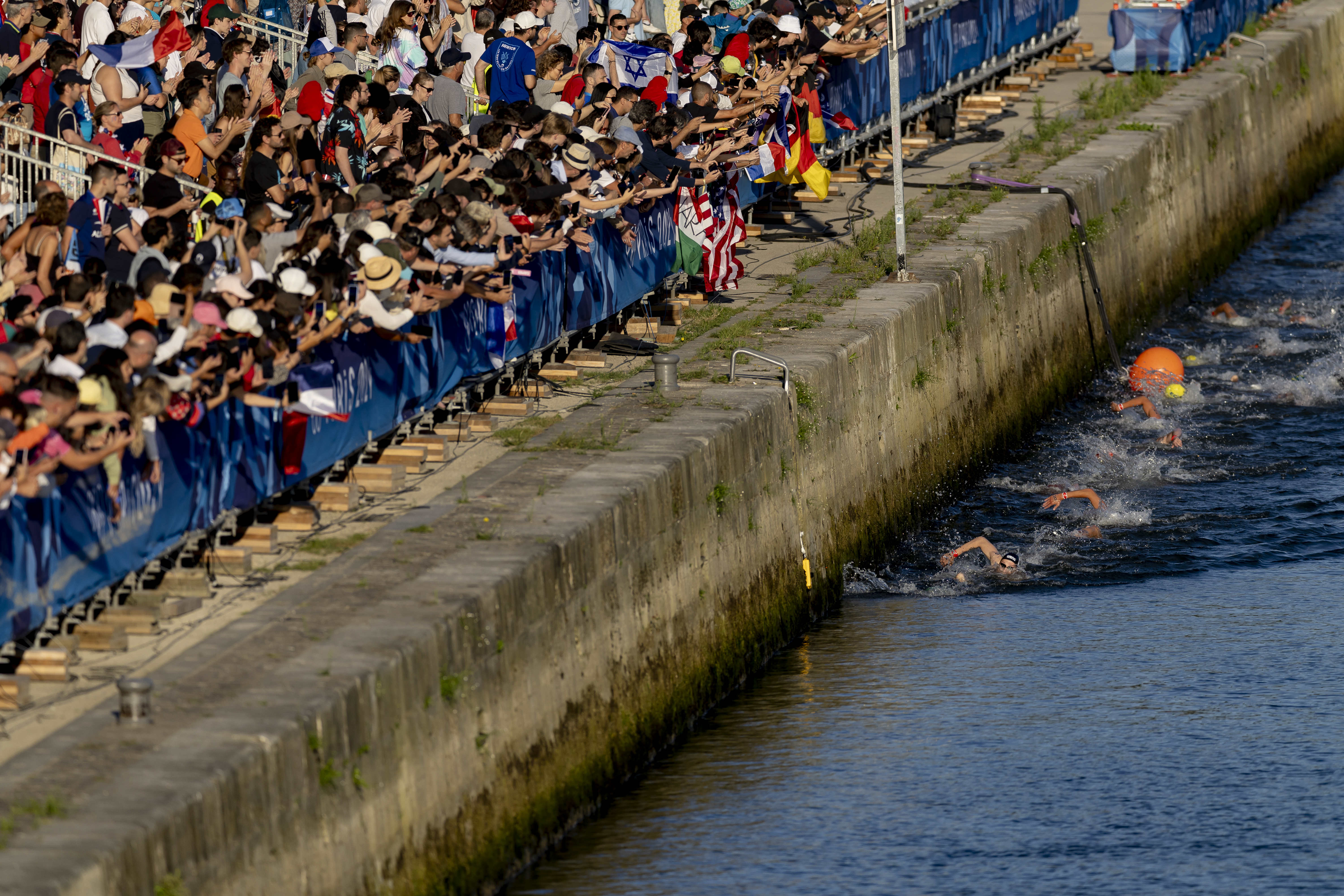 Spectators watching the Olympic Open Water competition along the Seine