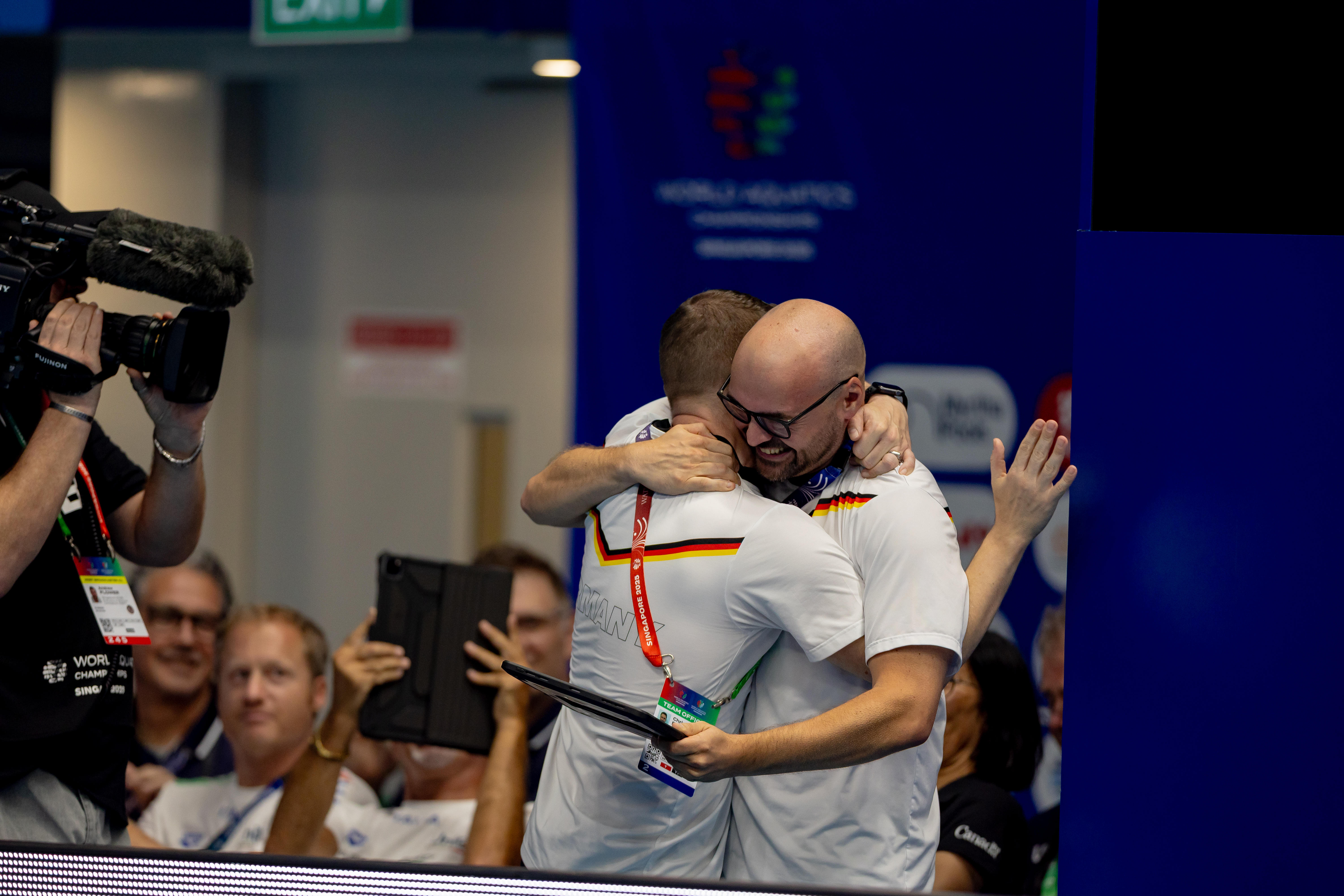 German coaches celebrating Pauline Pfeif silver medal at Singapore 2025