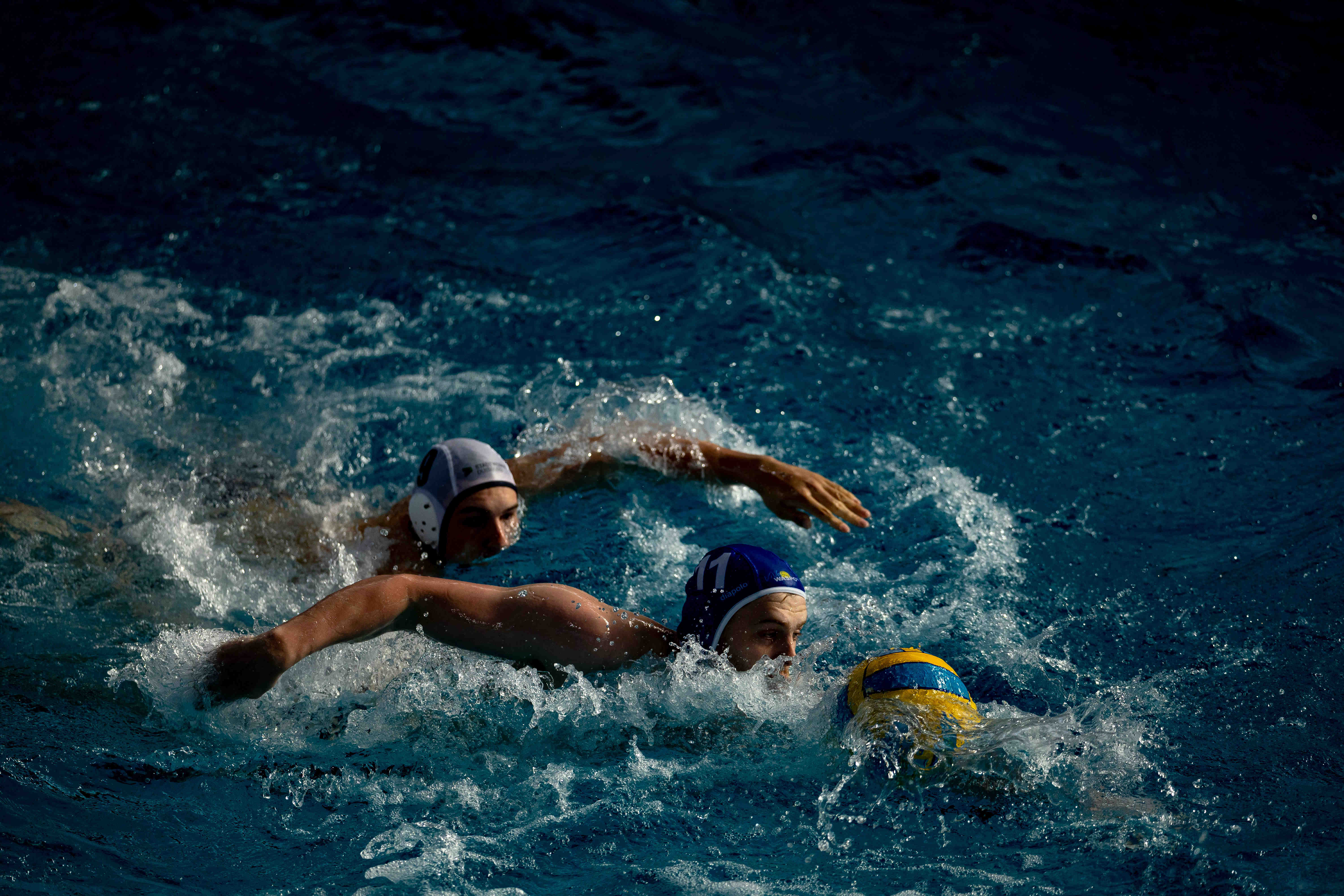 Water polo players sprinting in sunlight